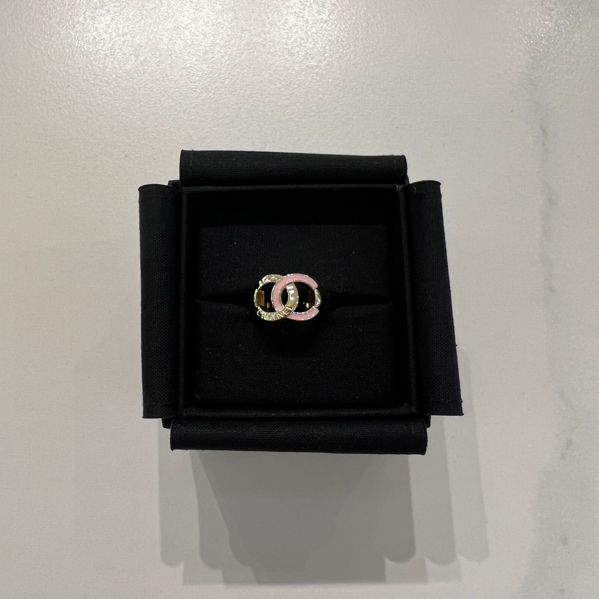 Chanel Ring，柔和粉色與金色金屬的搭配，點綴品牌雙 C 標誌，是高雅的必備配飾。