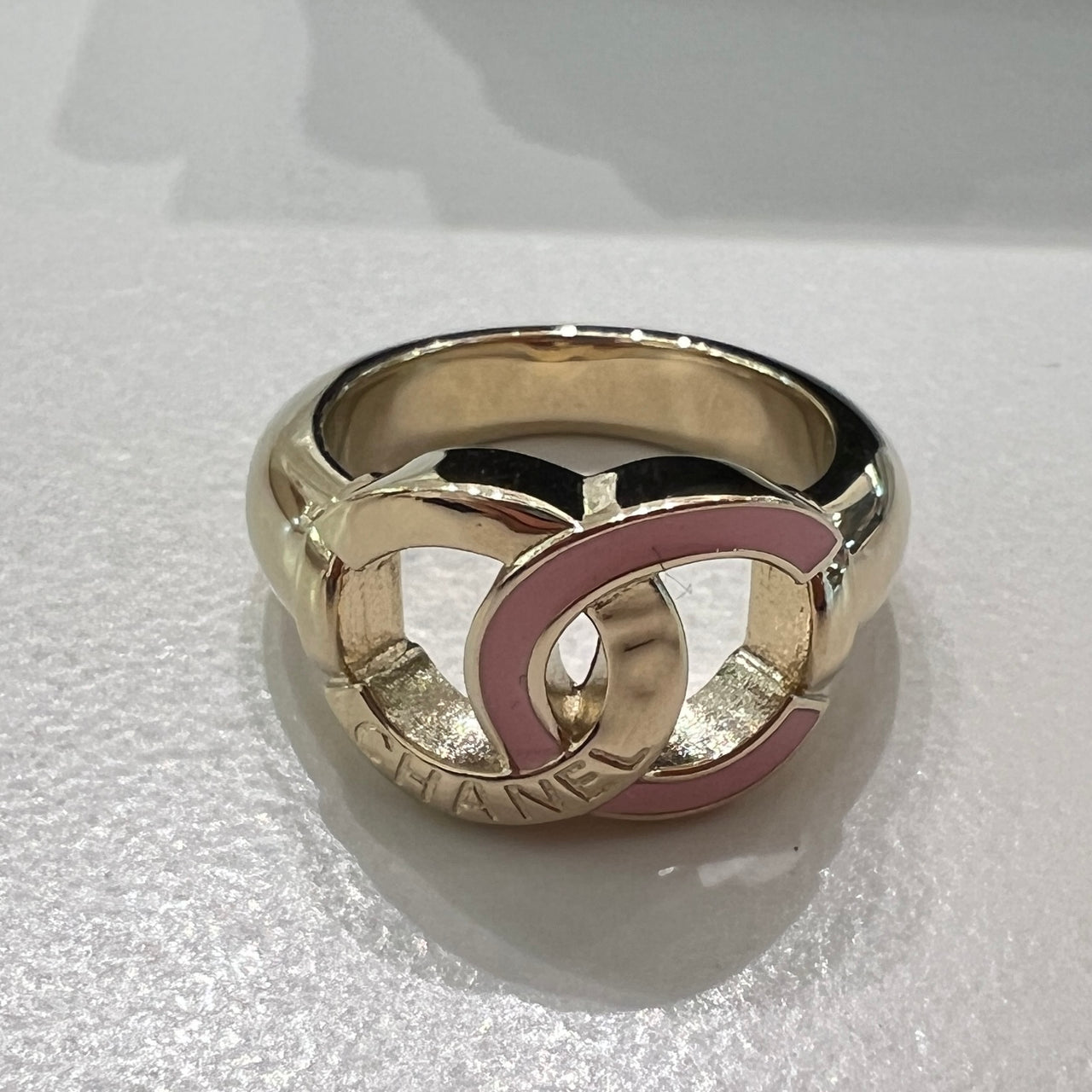 Chanel Ring，柔和粉色與金色金屬的搭配，點綴品牌雙 C 標誌，是高雅的必備配飾。