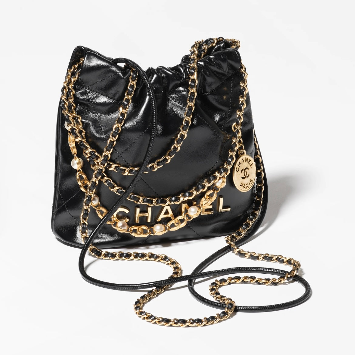 CHANEL 22 Pearl Handbag，黑色亮面小牛皮，珍珠鏈條與雙用背法設計，完美平衡時尚與功能。