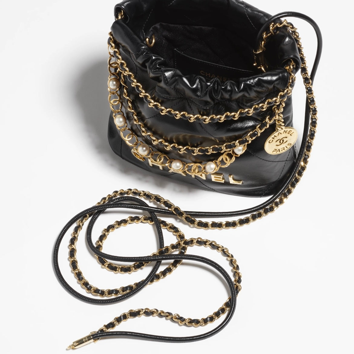CHANEL 22 Pearl Handbag，黑色亮面小牛皮，珍珠鏈條與雙用背法設計，完美平衡時尚與功能。